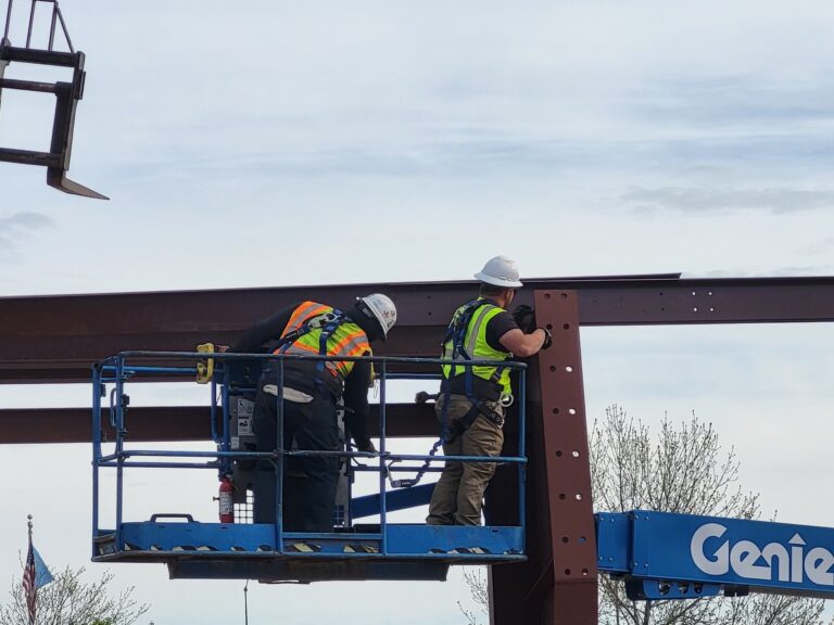 Close up of workers installing structural steel at Camp Rapid